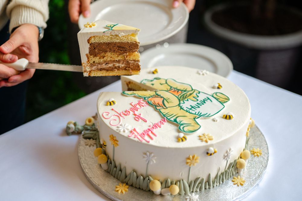 Multiple views of a white frosted cake decorated with yellow and green floral designs on a table setting.