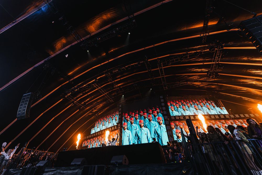 A panoramic view of a concert stage with dramatic lighting and curved architectural elements creating a dynamic atmosphere.