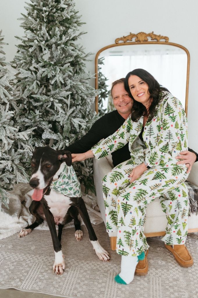 A sequence of photos showing two people in matching leaf-print pajamas posing with a black and white dog near a snowy tree.
