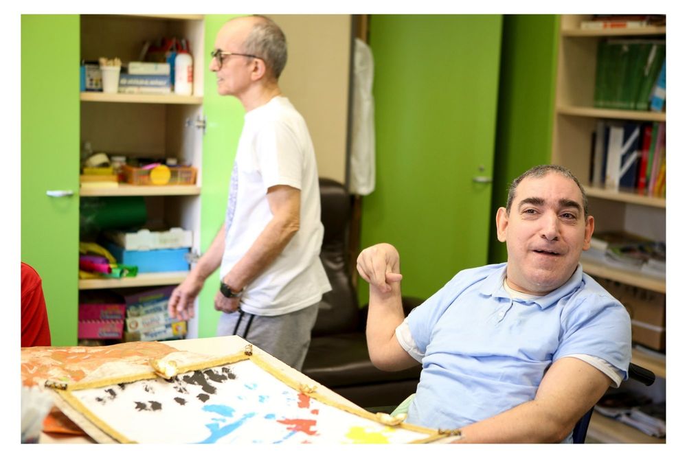 People playing board games and socializing around a table in a room with bright green walls.