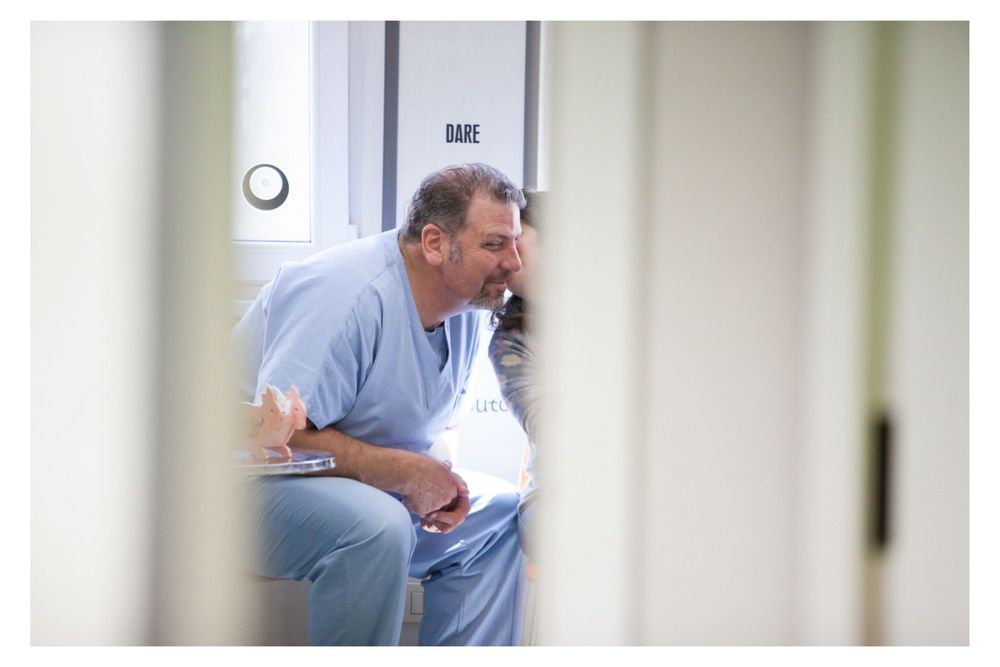 Medical staff members collaborate and work together in a hospital hallway setting.