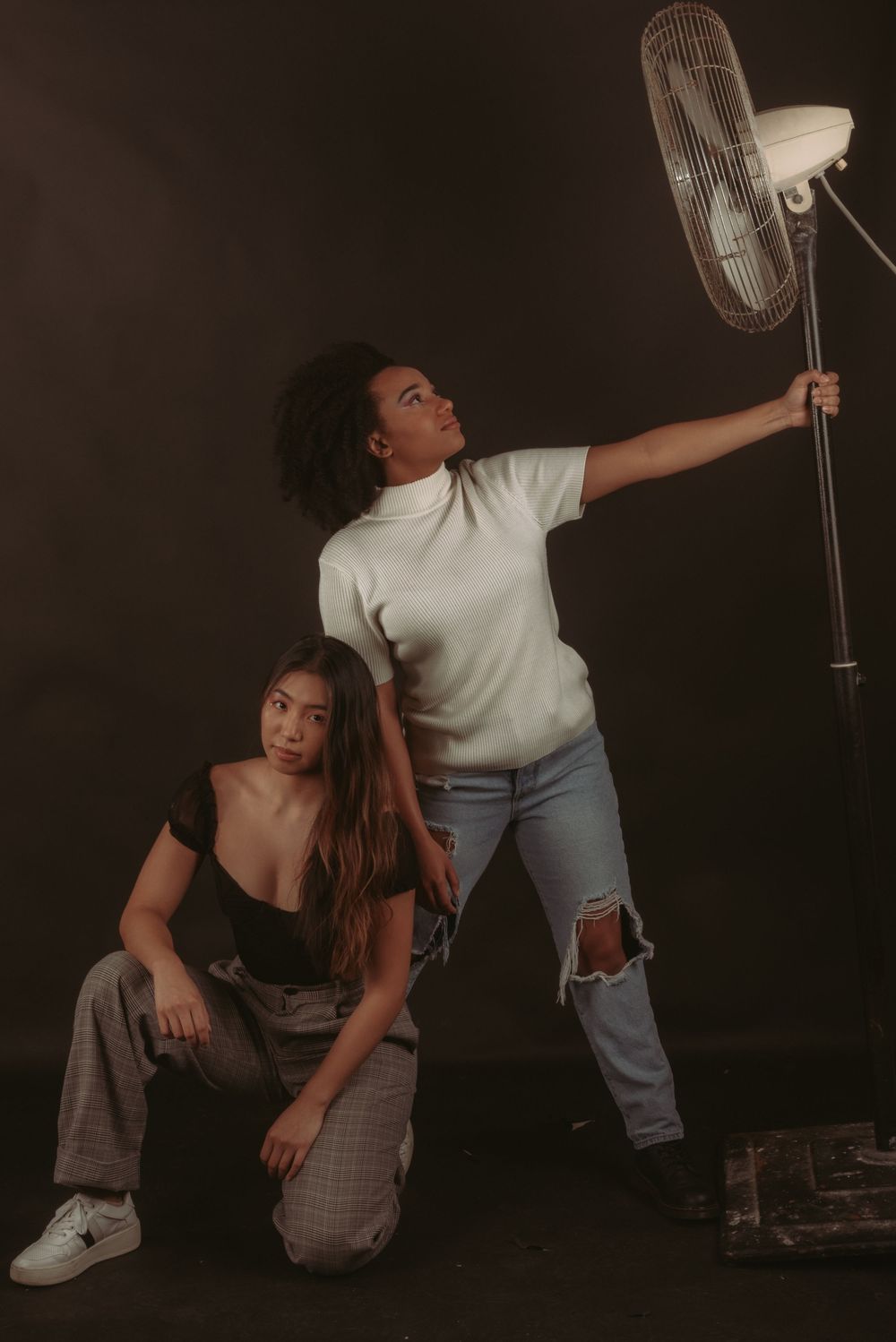 Dynamic editorial photo sequence with vintage fan and casual attire against dark studio backdrop.