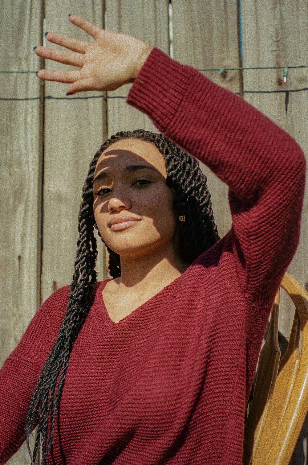 Outdoor portraits in burgundy sweater showing joyful expressions in natural sunlight.