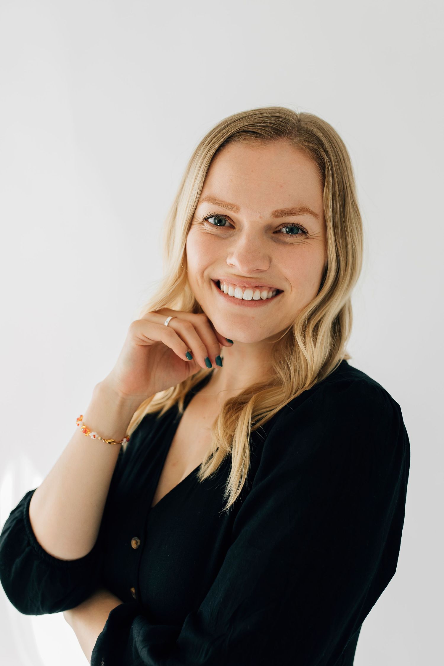 Professional headshots of a person in a black blazer smiling against a light background.
