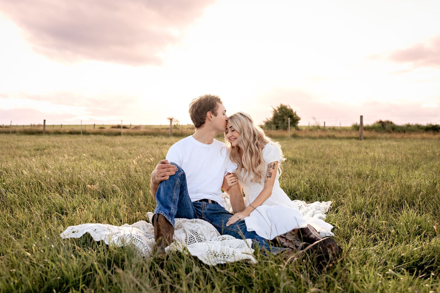 Extended family wearing white clothing poses together outdoors for casual portrait session in natural setting.