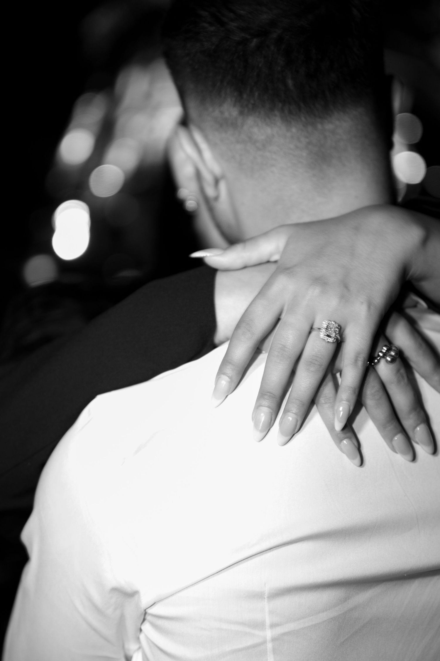 A sequence of black and white photos showing hands with rings resting on a white surface, creating an artistic composition.