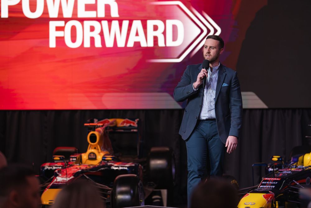 Corporate event stage with Power Forward branding and red illuminated backdrop.