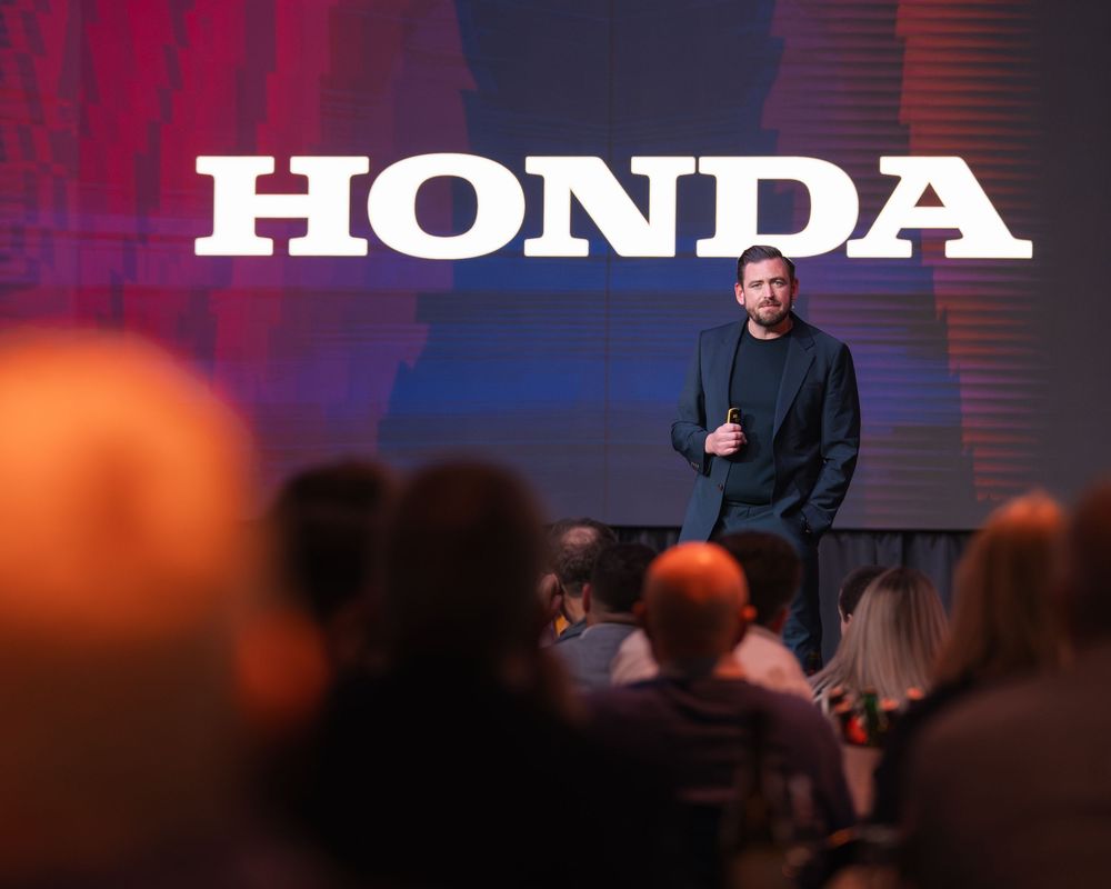 Honda branded presentation stage with dramatic red and blue lighting effects.