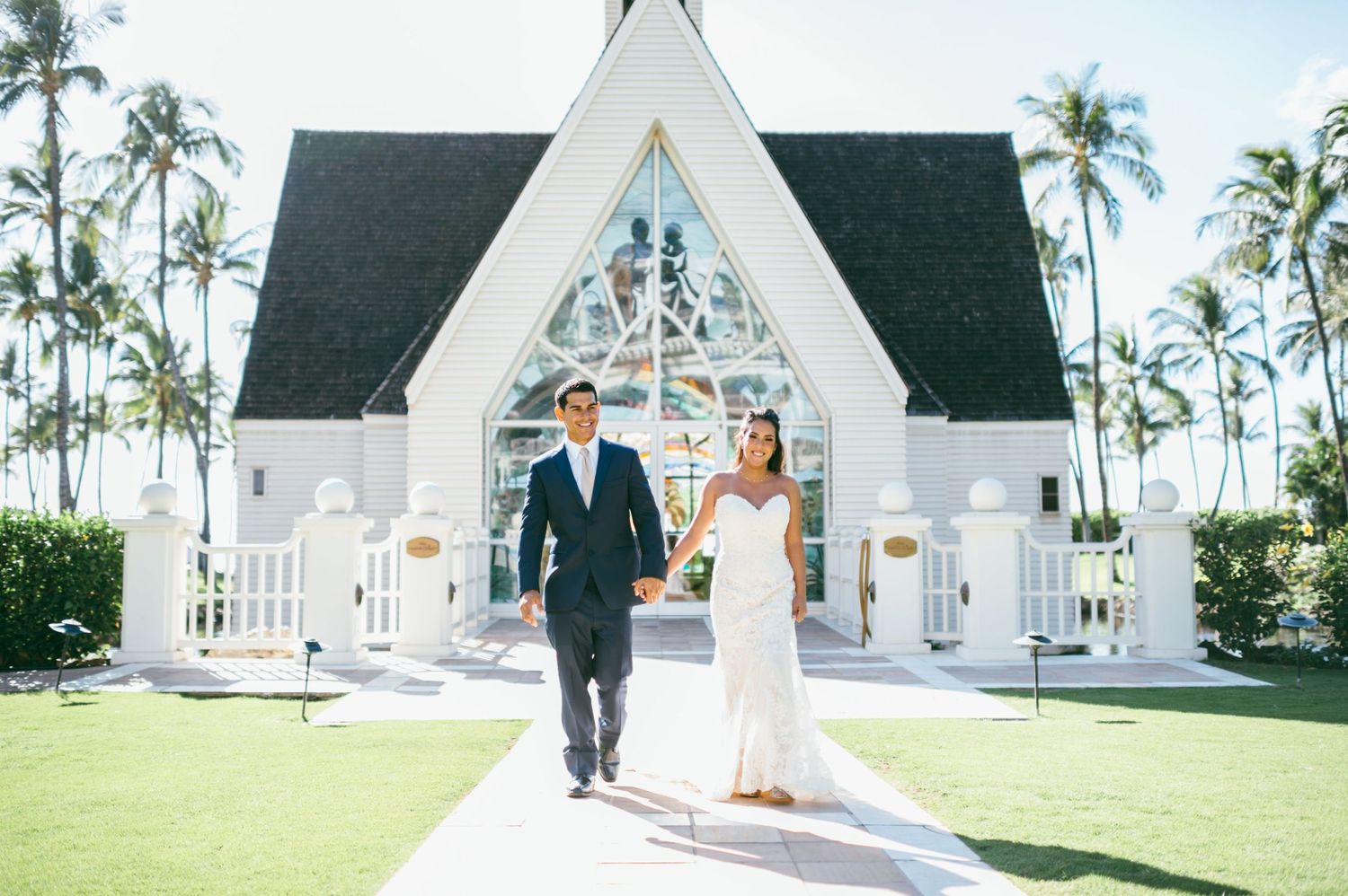 White chapel wedding venue with palm trees and tropical landscaping in Hawaii.