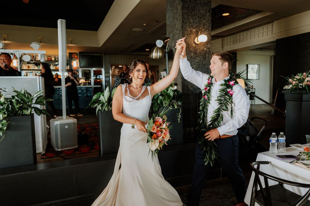 Wedding guests dancing and celebrating together on the dance floor at an indoor reception venue.