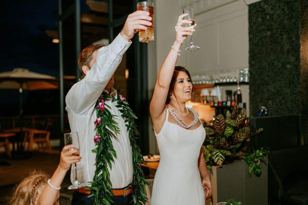 Wedding guests raising glasses in a toast during reception celebrations.
