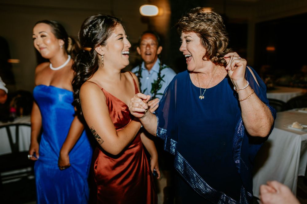 Wedding guests dancing and mingling during evening reception festivities.
