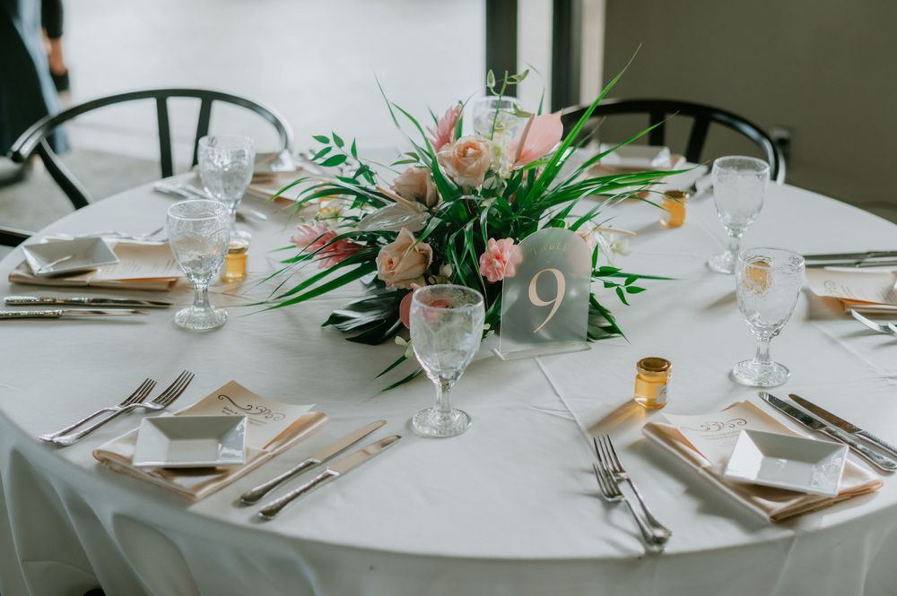 Modern wedding reception table settings with floral centerpieces and place settings.
