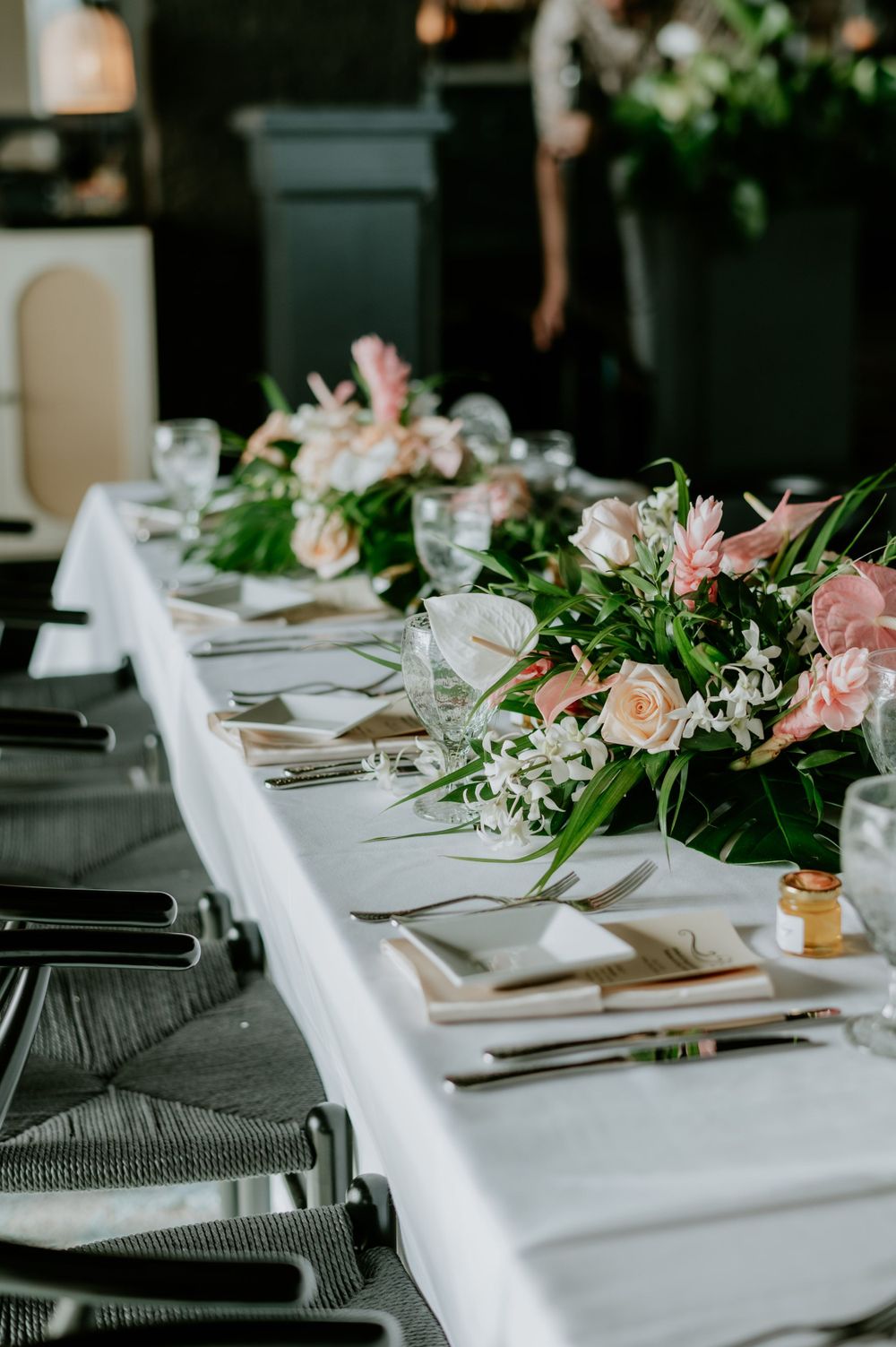 Elegant wedding reception table setting with pink floral centerpieces and white linens.