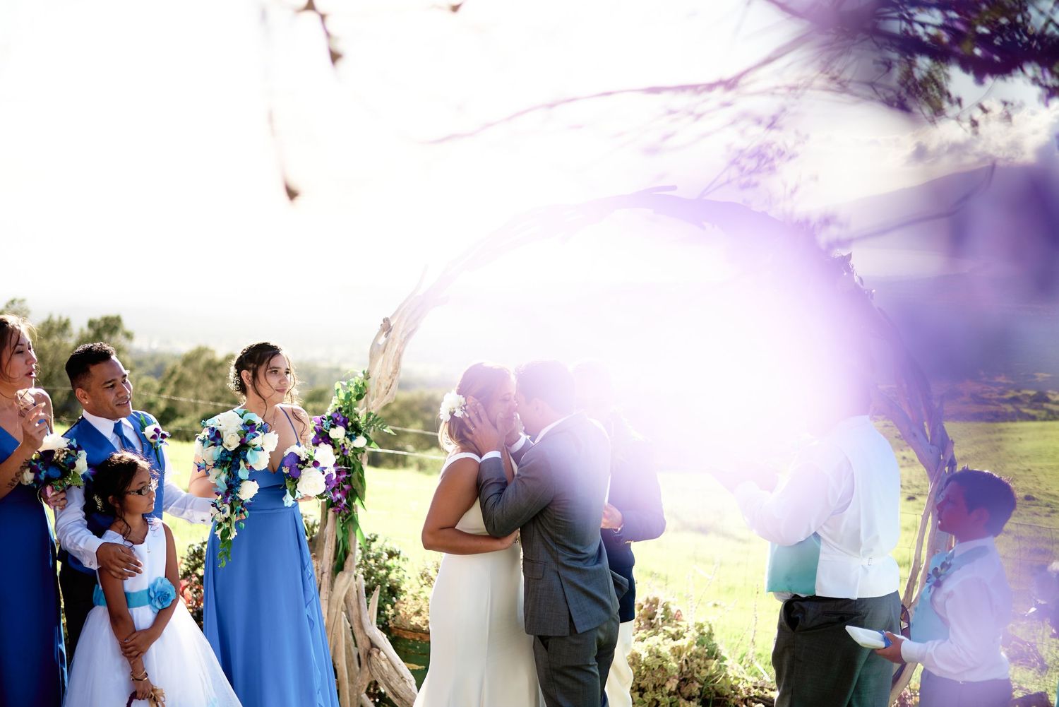 Wedding celebration on a scenic hilltop with bright sunlight creating a magical atmosphere.