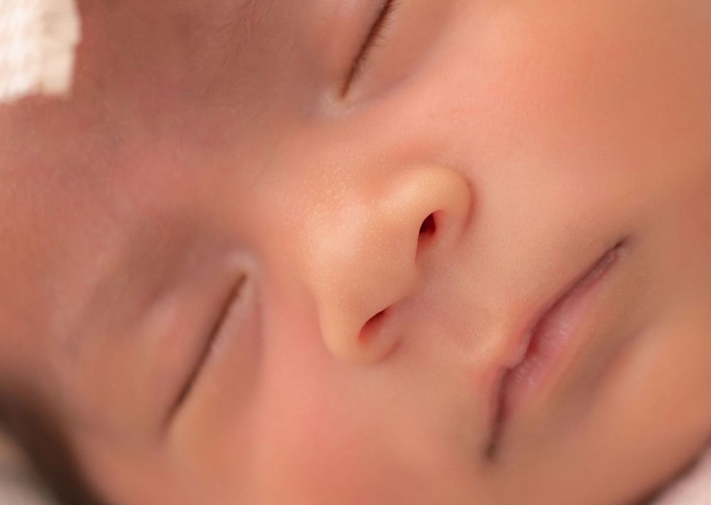Close-up of a peaceful sleeping newborn baby with soft skin and delicate features.