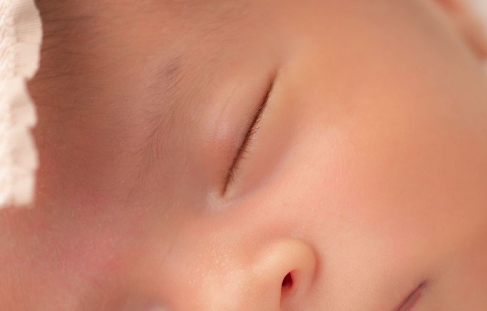 Close-up of a peaceful sleeping newborn baby with soft skin and delicate features.