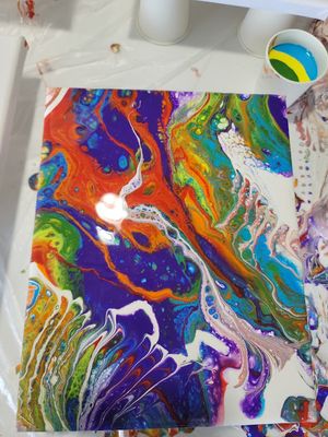 Abstract fluid art painting with swirling patterns in bright rainbow colors on white canvas.
