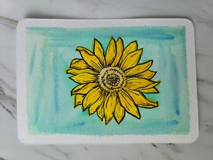 Bright yellow sunflower painted in watercolor against a mint green background.