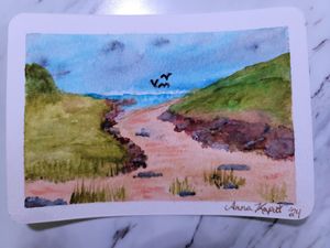 Beach path watercolor painting with green hills and birds flying in a blue sky.