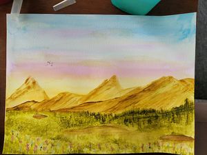 Watercolor landscape painting of mountain peaks during sunset with green forest in foreground.