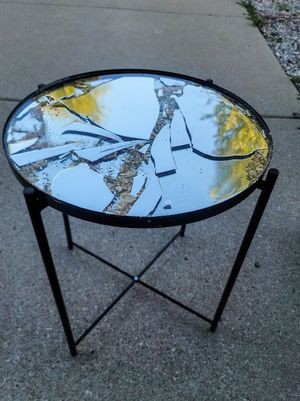 Modern side table with cracked mirror top surface featuring yellow and silver accents.