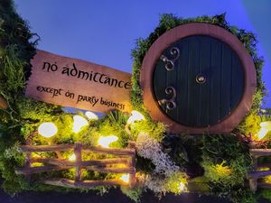 Whimsical round door with 'No admittance except on party business' sign and glowing lights.