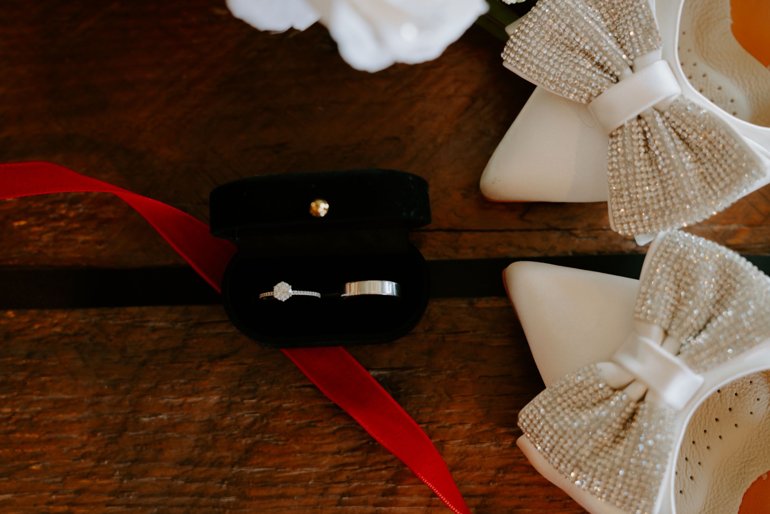 Wedding accessories including ribbons and bows arranged on a rustic wooden table.