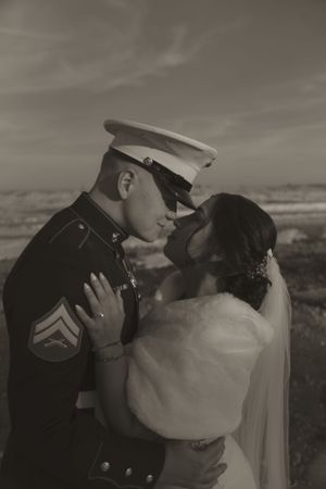 Romantic sepia-toned portrait of a military wedding couple in an intimate embrace.