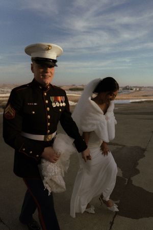 A couple shares a playful moment on the beach during their wedding photoshoot.