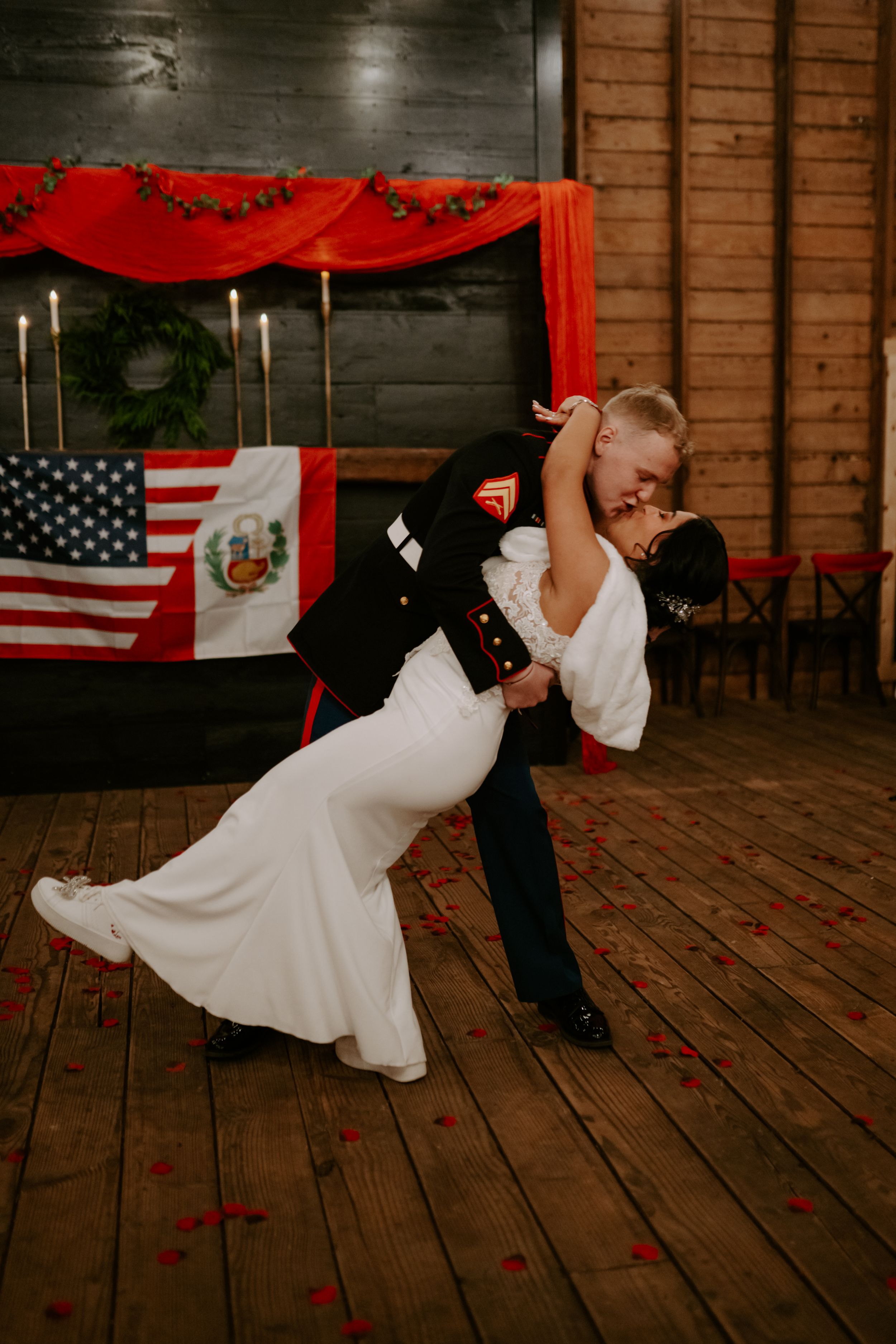 A romantic dip during the first dance at a military wedding with patriotic decorations.