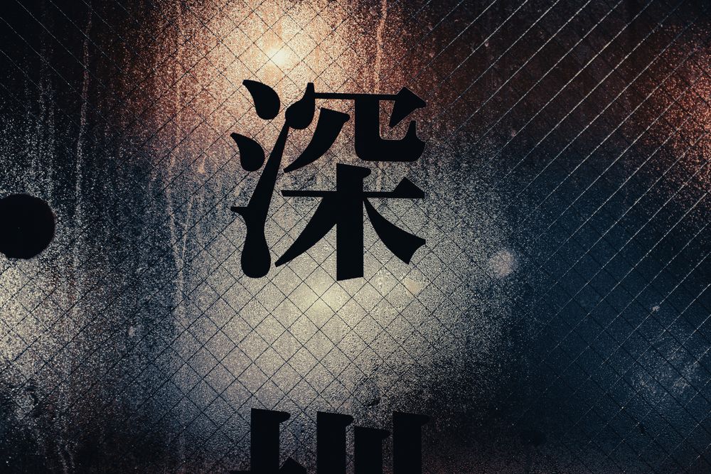 Artistic photo of illuminated Chinese characters with textured background and dramatic lighting.