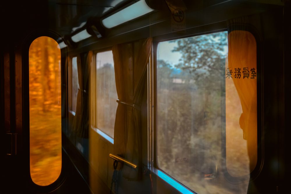 Warm sunlight streaming through train windows creating golden interior atmosphere.