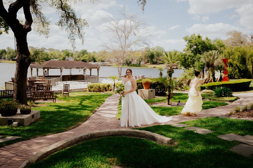 Elegant wedding celebration at a waterfront venue with a dock and tropical landscaping on a sunny day at enzos on the lake
