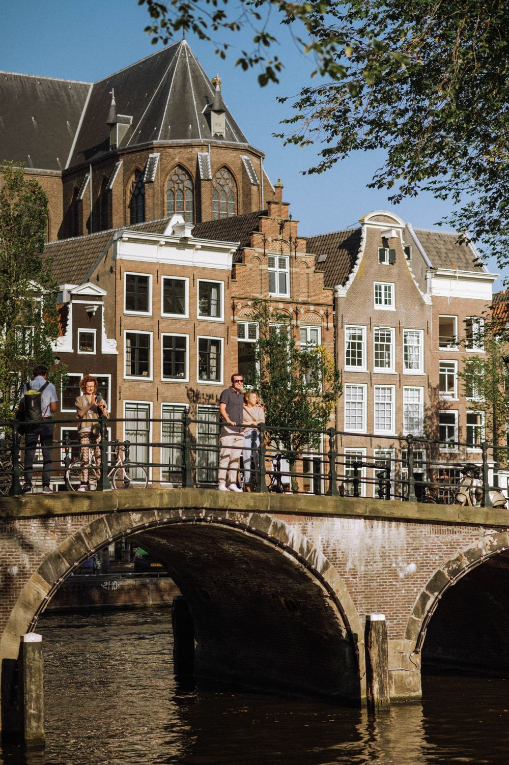 Historic Dutch architecture and canal bridges in Amsterdam on a sunny day.