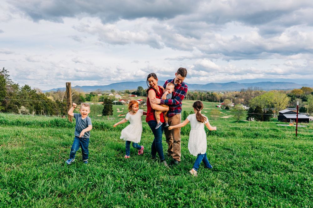 Photo of a family and children playing during a family portrait session at a farm in Dandridge in East Tennessee by portrait photographer