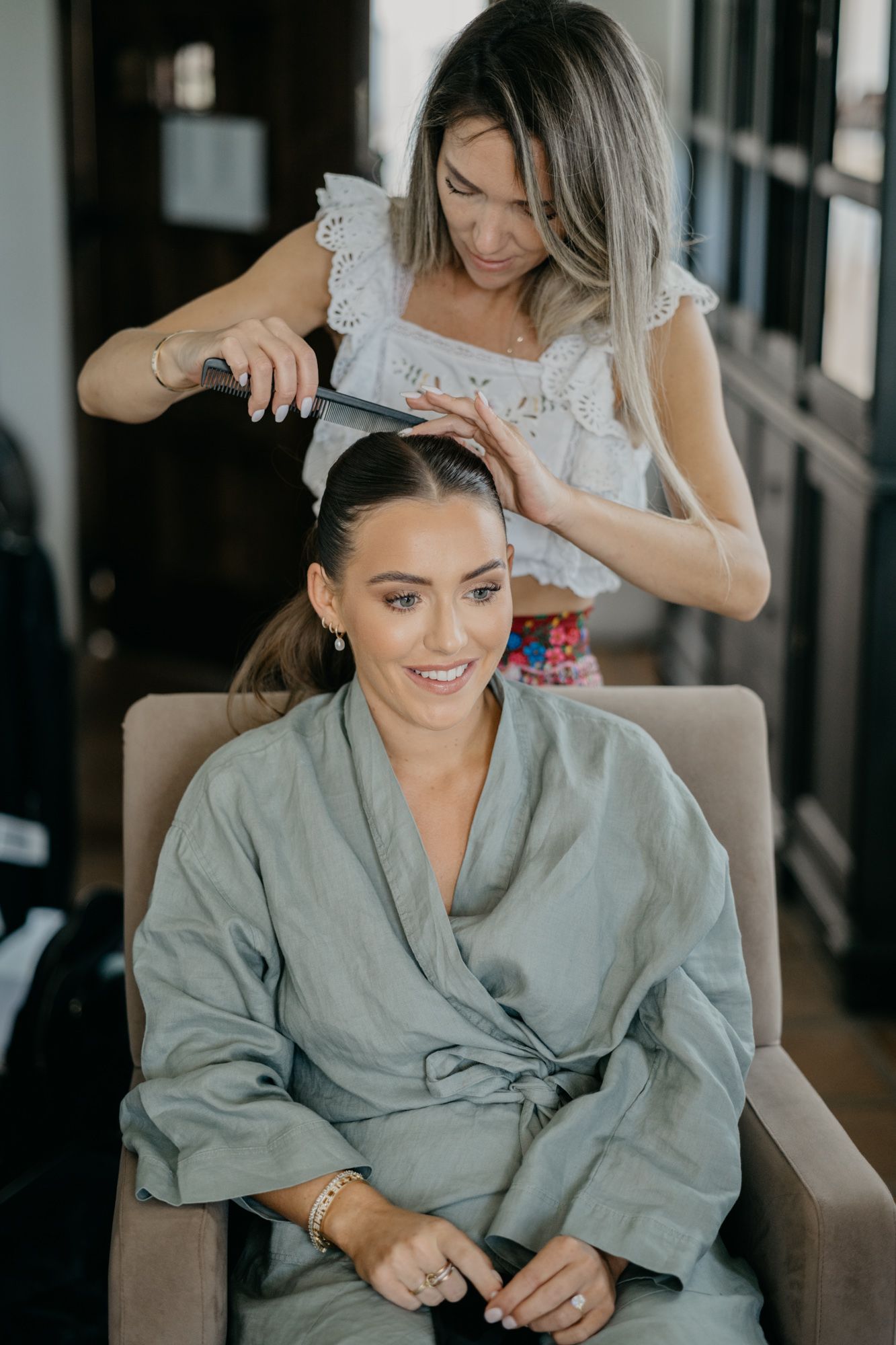 Wedding preparation scene with styling and robes in interior setting.