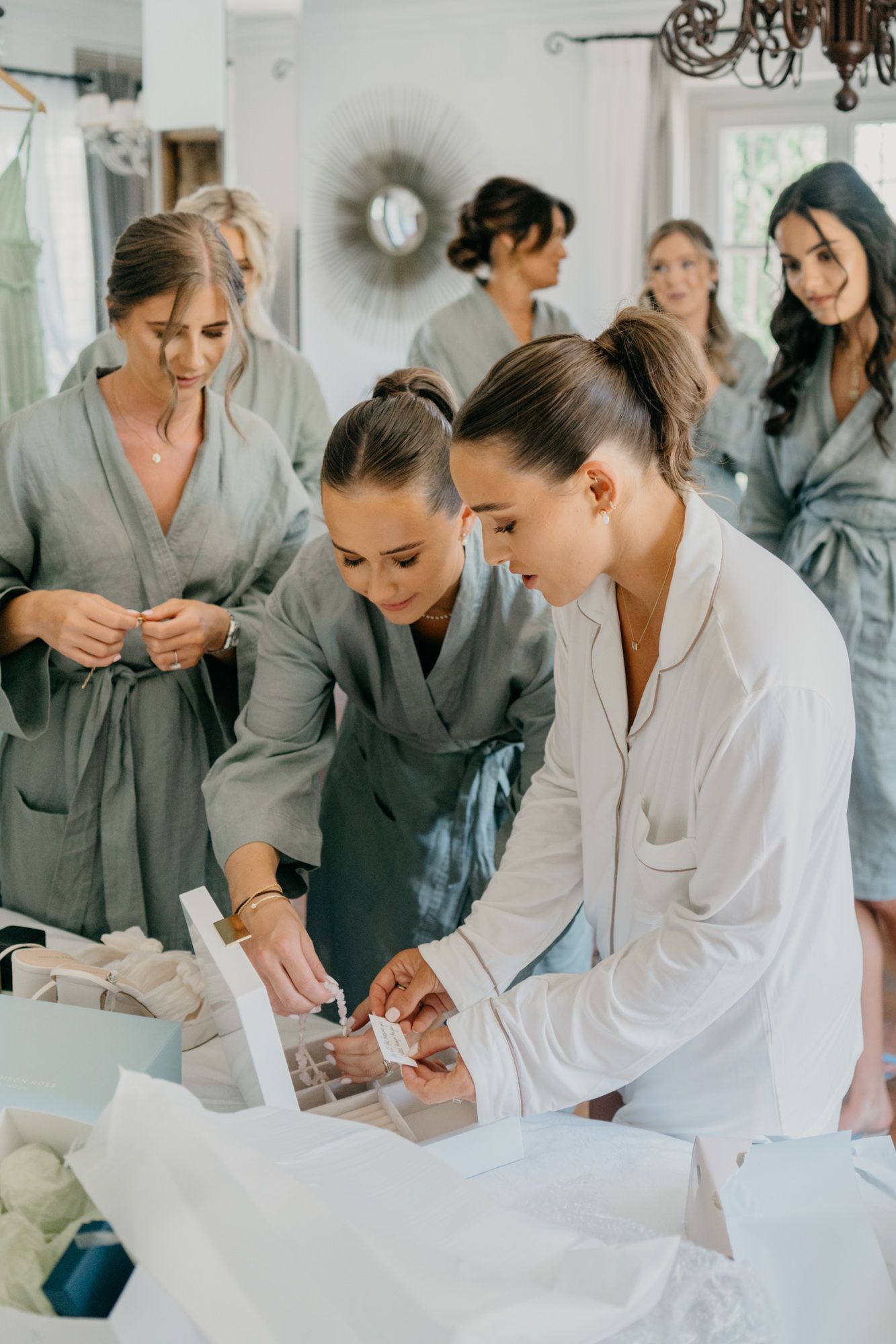 Wedding party getting ready in robes as they prepare for the special day in a bright room.