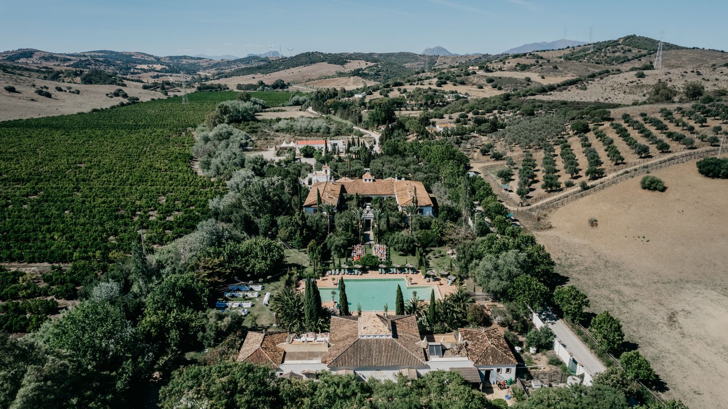 Aerial photograph of a Tuscan-style estate with pool surrounded by vineyards and rolling hills.