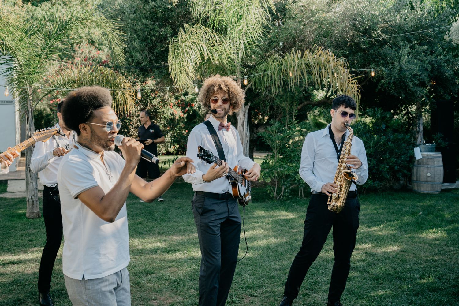 Live band performing outdoors with multiple musicians and instruments.