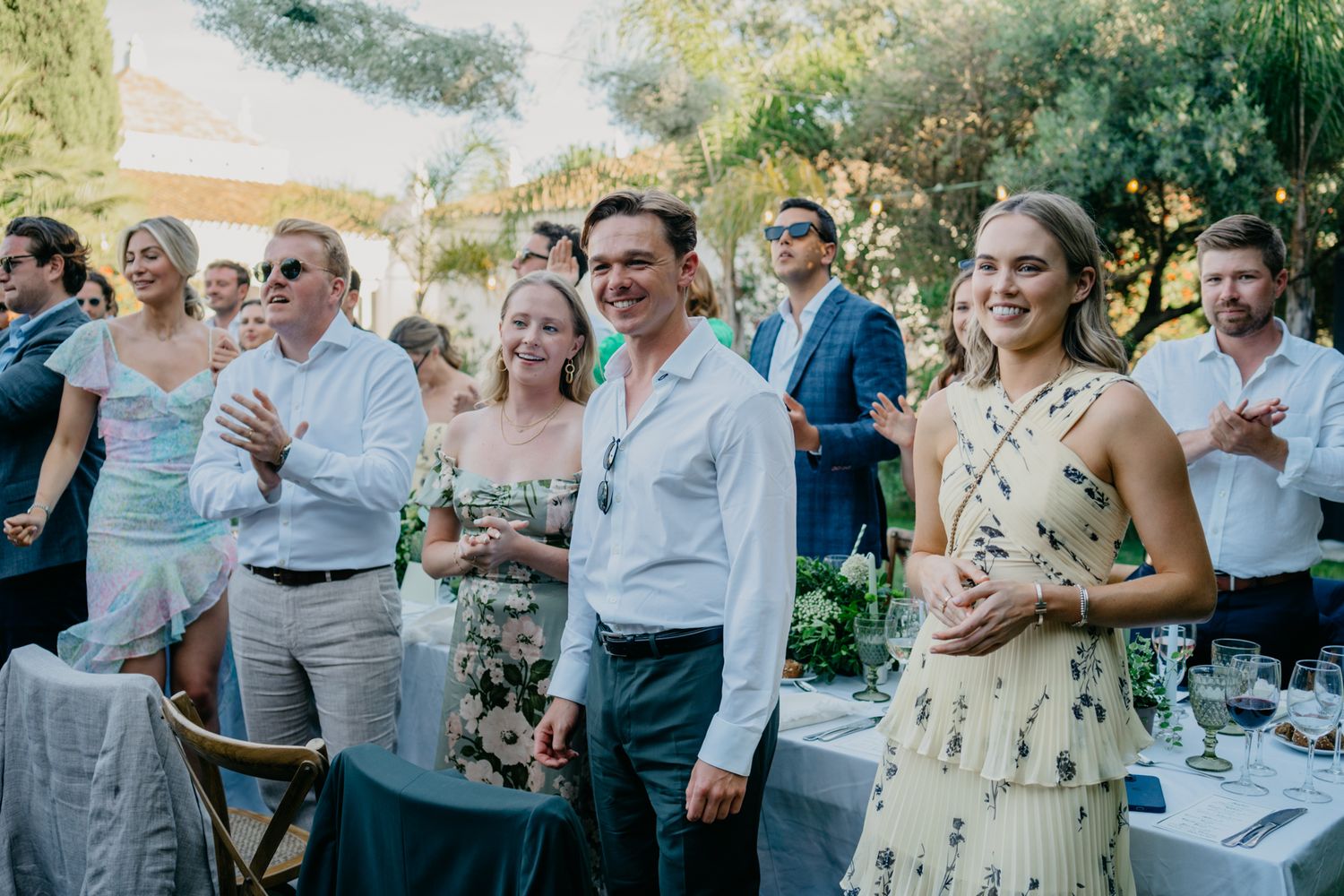 Guests enjoying an outdoor wedding reception with casual summer attire.