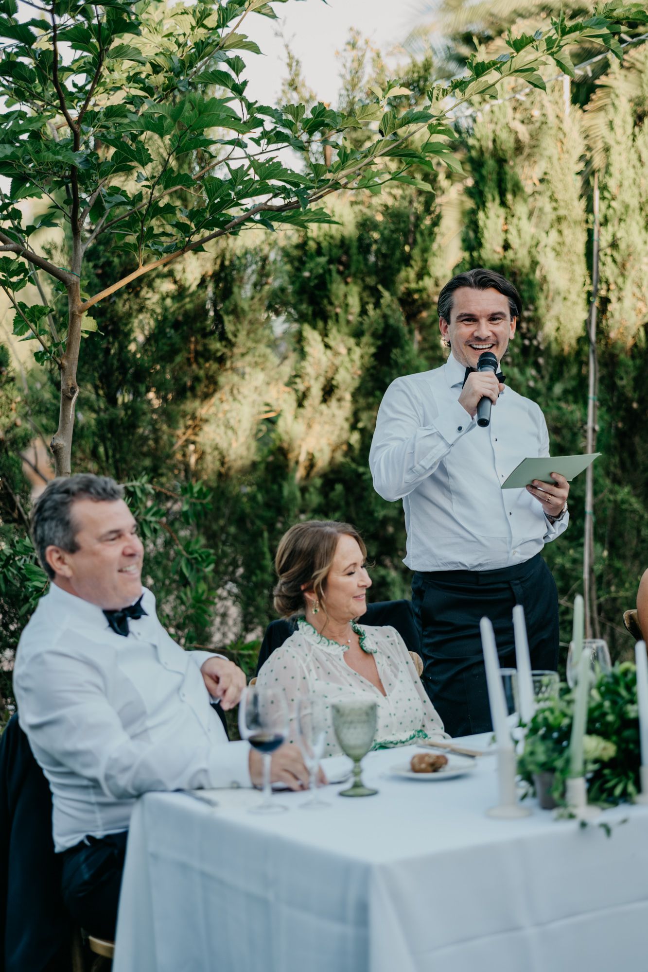 Wedding speeches being delivered at outdoor reception dinner.