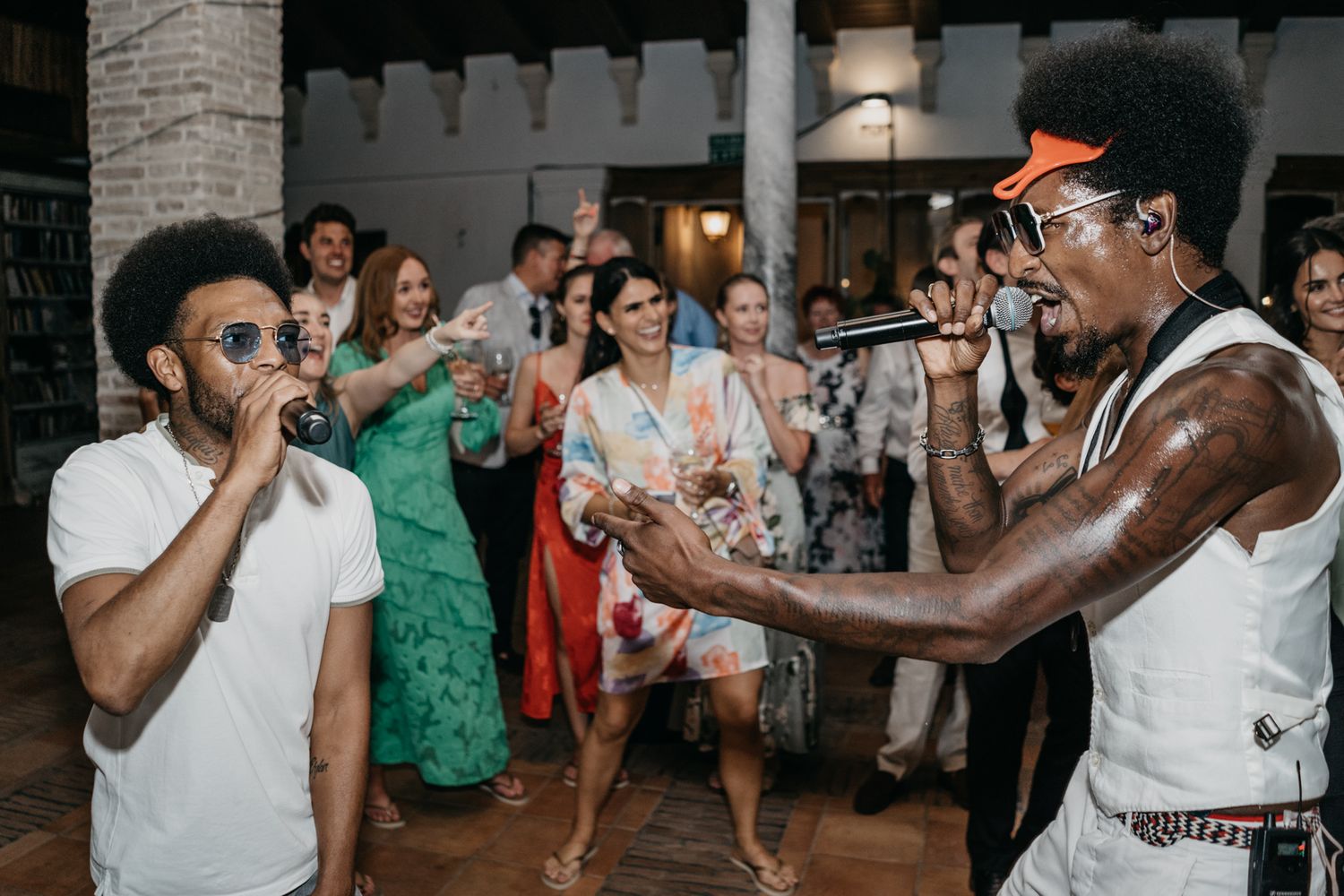 Wedding party guests dancing and enjoying entertainment at an indoor reception.