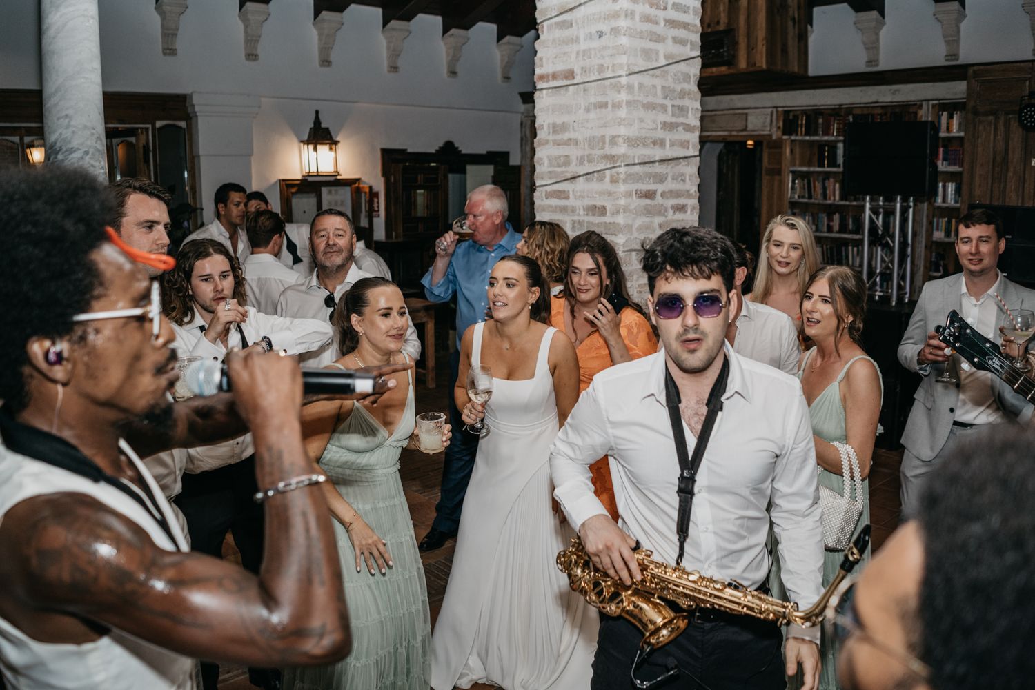Wedding reception party with live saxophone music and dancing guests.