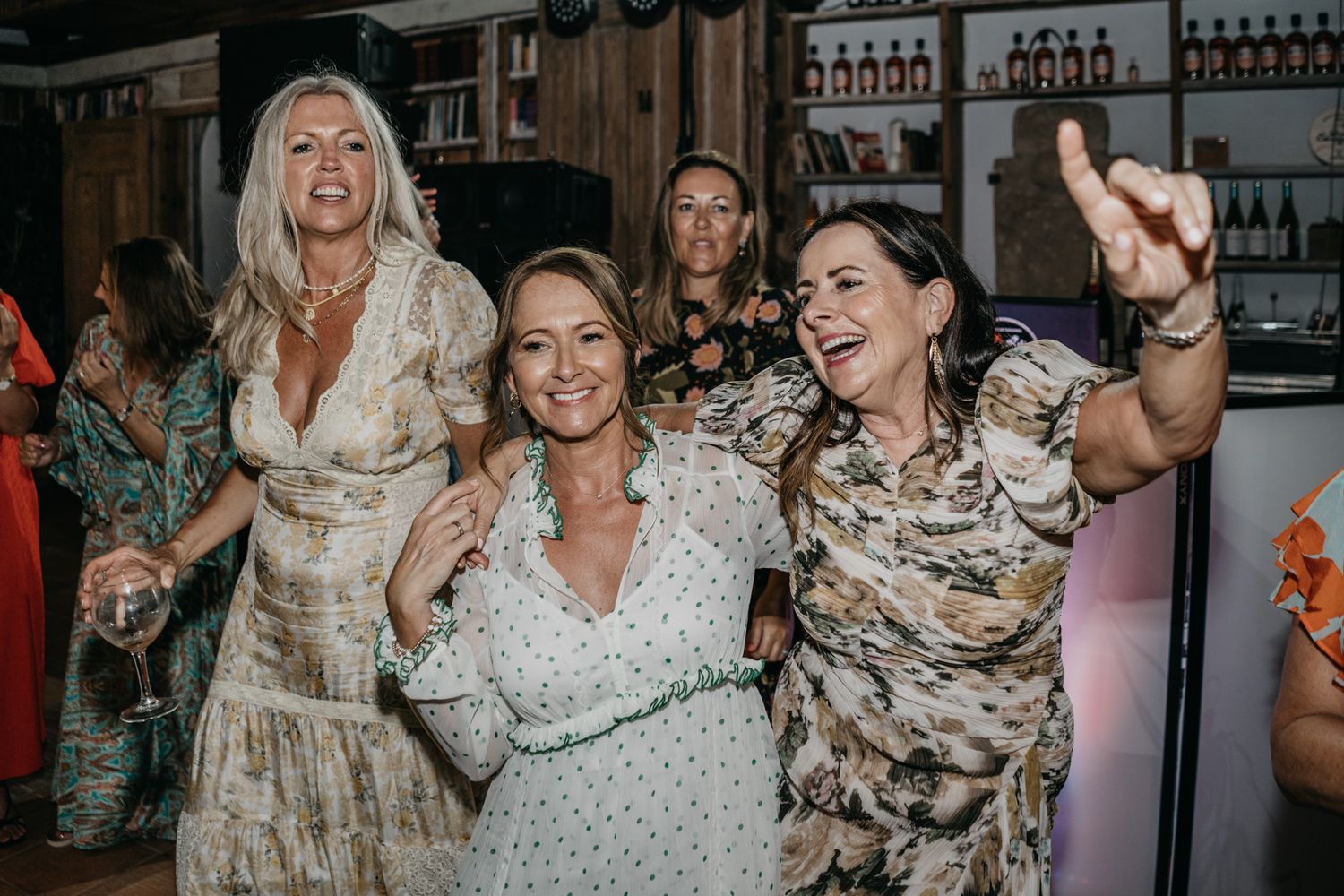 Wedding guests dancing and celebrating joyfully on the dance floor at a reception party.