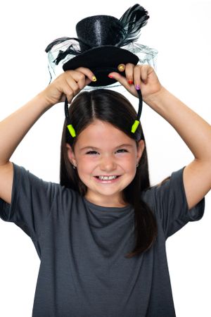 Child wearing top hat Mickey ears with neon accents against white background modeling for Hug A Band.