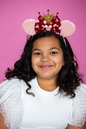 Glittery red and gold crown Mickey ears headband with pink sparkly ears modeling for The Minnie Castle.