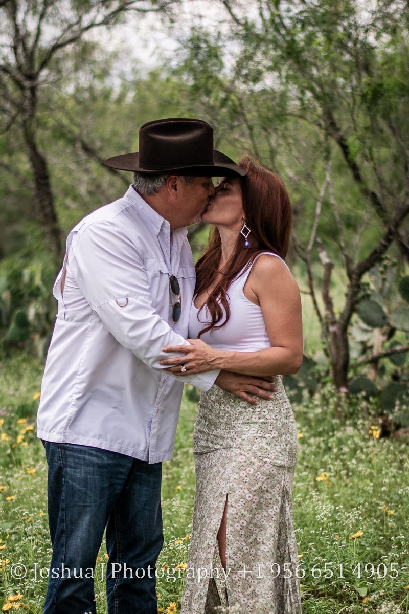 Husband and Wife kissing on their ranch.