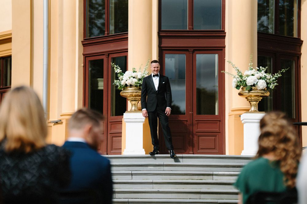 Elegant stone building entrance with cream colored columns and steps.