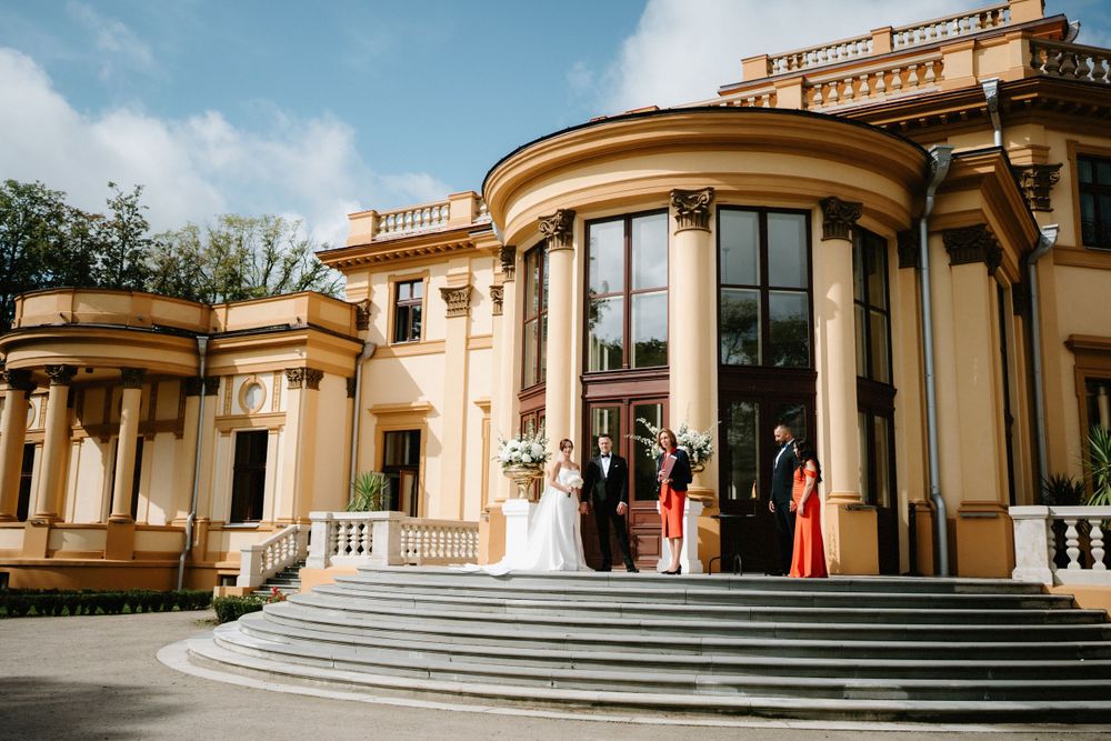 Grand neoclassical building with cream columns and curved steps in warm sunlight.